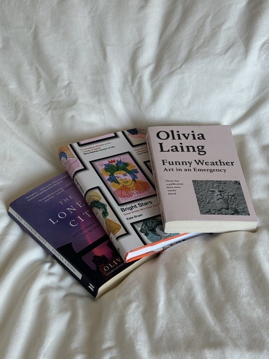 Three Olivia Laing books on white sheets