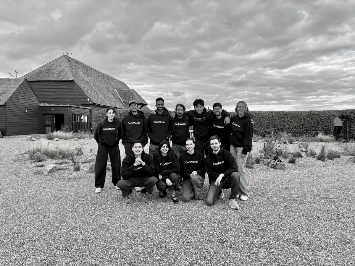 The CodeWords team in branded hoodies outside a barn